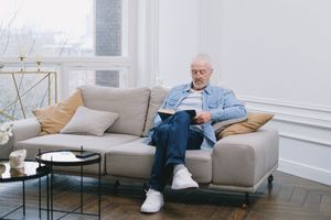 Older man reading a book in living room